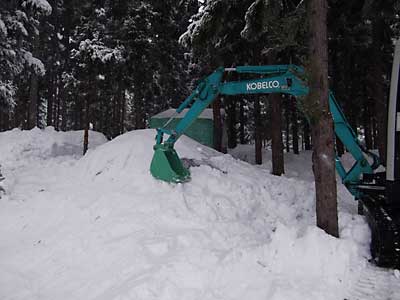 ユンボで雪室の回りに雪を入れて固めました。