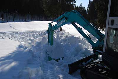 雪をバケットですくって天地返しをします。