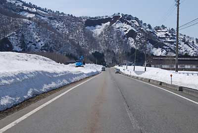 雪消えが遅くならないように、ユンボで雪の天地返しの作業をしています。